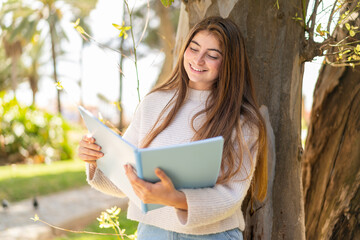 Young pretty caucasian woman holding a notebook