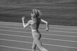 © Yevhen - Female jogger runner running outdoors, runner. Fitness woman on stadium. Young fitness woman runner running on stadium track. Woman in sportswear jogging on stadium