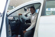© Parilov - Handsome African American man customer client in suit get out car, touch door. Concept sales automobile in showroom vehicle store