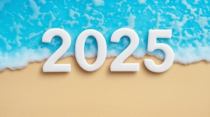 A beach with the number 2025 written in white letters on the sand. The beach is surrounded by water, and the letters are placed in a way that they appear to be floating on the sand