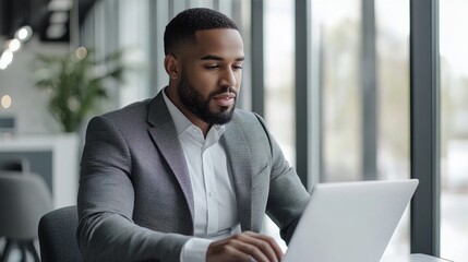 Canvas Print - businessman working on a laptop in a modern office, focusing on e-commerce