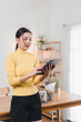© kenchiro168 - Asian woman working on digital tablet at desk.