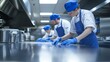 © Elmira - A dedicated team of three, dressed in blue overalls and white shirts, diligently cleans countertops in a bustling commercial kitchen, ensuring everything is spotless