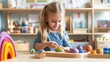 © Elmira - The blonde girl smiles as she concentrates on a hands-on activity, manipulating vibrant shapes in a Montessori classroom designed for interactive learning