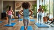 © Charoen - Family members enjoying an at-home workout session, with yoga mats and fitness equipment spread out in the living room.