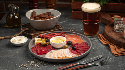 Wall Mural - Portion of meat appetizer platter with beer and garlic bread