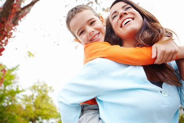 Mom, boy and happy in outdoor on piggyback for fun with bonding, support and care for break. People, parent and smile with kid for child development, growth and childhood memories in England