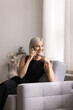 © fizkes - Beautiful middle-aged woman making call seated on cozy armchair at home, receiving professional consultation, lead talk to close friend, speaking to customer services share news. Communication, tech