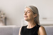 © fizkes - Close up mature woman closing her eyes resting seated on sofa at home, taking break from daily activities, allowing herself to recharge, rejuvenate, meditate and ponder, boost inner peace and serenity