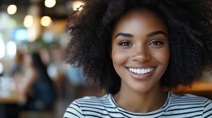 Wall Mural - Close up shot of adorable African American woman has broad smile wears striped t shirt being in good mood rests in cafeteria with best friends Smiling dark skinned young female poses i : Generative AI