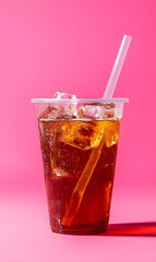 Wall Mural - Cold tea drink in plastic cup isolated on pink background