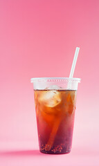 Wall Mural - Cold tea drink in plastic cup isolated on pink background