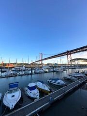 Poster - Boats docked in the harbour with 25 April Bridge in the background. Taken in Lisbon Portugal. 