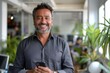 © Art Gallery - Smiling mature Latin or Indian businessman holding smartphone in office. Middle aged manager using cell phone mobile app. Digital technology application and solutions for business, Generative AI