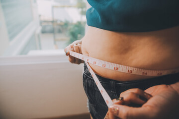 fat woman, fat belly, chubby, obese woman hand holding excessive belly fat with measure tape, woman 