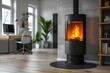 © JIALU - Modern black wood stove with flames in office room, light grey walls and floor, white desk chair, wooden shelf, Nikon D850 shot.