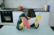 © Alexandr - Exhausted Maid Sitting at Kitchen Table, Overwhelmed by Fatigue