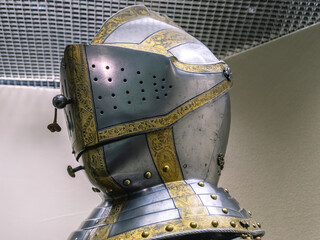 A medieval knight's helmet with carved gilded decorations. Knight's armor. The steel helmet of a warrior.