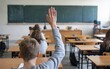 © RMedia - Kid school student raising hand at classroom