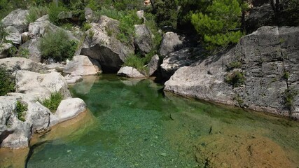 Wall Mural - Forward reveal aerial shot of small pool on the Brugent river on sunny summer day. La Riba, Tarragona, Spain.