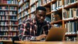 © Nany - A black college student studying in a library with a laptop