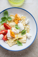 Poster - Blue and white plate with ravioli, ricotta cheese, tomatoes and fresh basil, vertical shot, top view, middle closeup