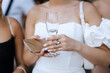 © shchus - Woman, a guest invited to the celebration, holds a glass of champagne and an envelope with a cash gift at the ceremony. Wedding photography, portrait.