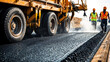 © bluebeat76 - Road construction crew paving a new asphalt road