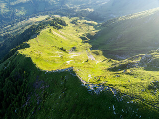 Aerial view of mountain landscape in Switzerland. Peaks in Gantrisch nature park in Swiss alps. Beautiful panorama in morning sunlight with blue sky.