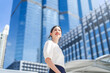 © dodotone - Portrait of successful business asian woman standing looking forward at outdoors in city