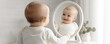 © Jayda_ArtistryHub - A joyful baby gazes at their reflection in a mirror, capturing innocence and happiness in a serene indoor setting.