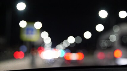 Blurred car lights bokeh in the evening city. Defocused headlights and street lighting at night. Moving bokeh circles of cars at night. Blurred city traffic background