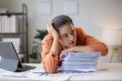© amnaj - Exhausted young manager woman feeling tired and stressed from working with laptop at office desk
