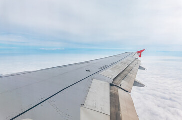 Wall Mural - View from the airplane window at a beautiful cloudy sky and the airplane wing