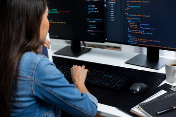 Wall Mural - Young Asian in IT developer creating with typing online information on pc with coding program data of website application, wearing jeans shirt. surrounded by safety analysis two screens. Stratagem.