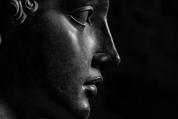 Wall Mural - Ancient Roman or Greek statue closeup, black marble. Side view with copy space. Sculpture, face of a mythological hero or a muse, portrait of god on black background