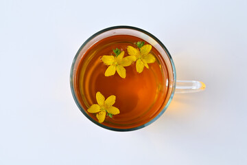 tea with St. John's wort flowers in a cup on a white background flat lay