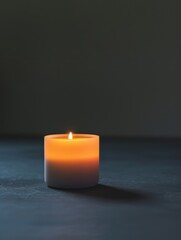 Wall Mural - Warm glowing candle in the dark