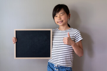 Happy Asian Chinese girl with blank blackboard