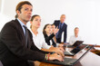 © JackF - Businessman using laptop during conference in meeting room. Man sitting at desk with colleaugues.