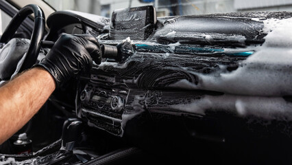 Wall Mural - A mechanic cleans the interior of a car with a brush and foam.