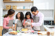 © Art_Photo - Portrait of enjoy happy love asian family father and mother with little asian girl daughter child play and having fun cooking food together with baking cookie and cake ingredient in kitchen