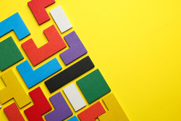 Poster - Colorful wooden puzzle pieces on yellow background, top view