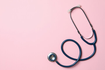 Wall Mural - Stethoscope on pink background, top view. Space for text