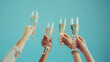 © pachara - Toasting with Champagne Glasses Against Blue Background