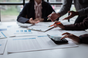 Wall Mural - Group of confident business people point to graphs and charts to analyze market data, balance sheet, account, net profit to plan new sales strategies to increase production capacity.	