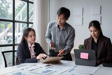 Wall Mural - Teamwork concept. Group of asian business people working together in creative office analyze market data balance sheet account net profit to plan new sales strategies to increase production capacity.