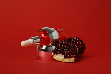 Wall Mural - Cosmetics with pomegranate on a red background.