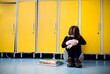 © Halfpoint - Bullied girl is crying by lockers. Bullying or teasing in elementary school.