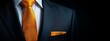 © Mikus - A tight shot of a man in a suit, featuring an orange tie and a folded pocket square in his lapel